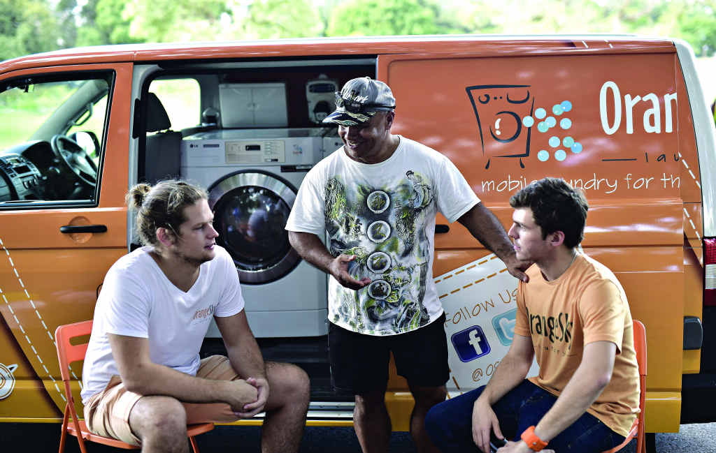 Luc Patchett and Nic Marchesi engaged in conversation beside one of their Orange Sky washing vans. Luc Patchett and Nic Marchesi engaged in conversation beside one of their Orange Sky washing vans.